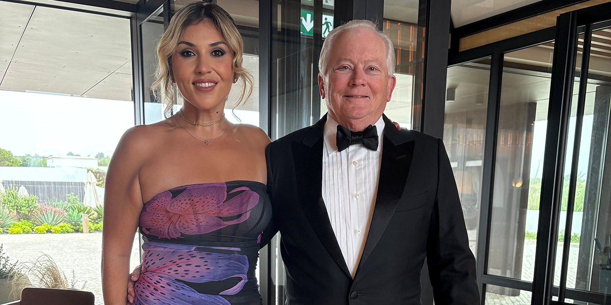 Stephen Stahl in black tie posing for a photo with a woman in a ball gown