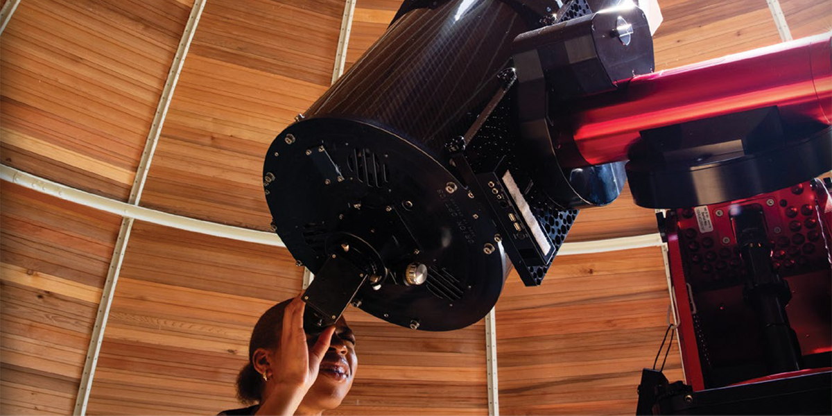 A woman looking through a large telescope