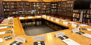 Meeting room lined with books and a table set out for the board of directors