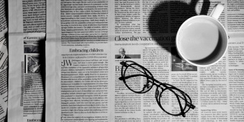 Image of newspaper with glasses and a cup of coffee