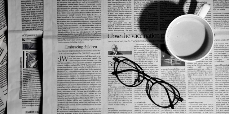 Image of newspaper with glasses and a cup of coffee