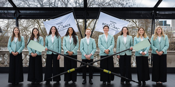 Cambridge rowing team in blue blazers posing for a photo.