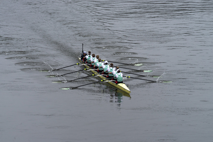 Long shot of Cambridge rowing team on a river