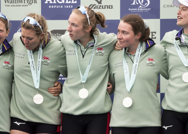 Close up of Larkin Sayre with medal and linked arms with team mates