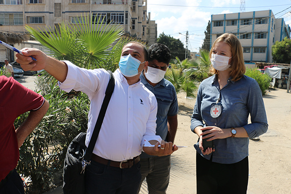 Emma Houiellebecq in a Gazan street with medical professionals. A man is pointing into the distance