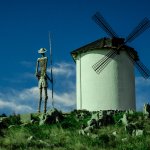 Picture of windmill and farmers looking out to a blue sky