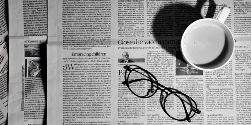 Image of newspaper with glasses and a cup of coffee