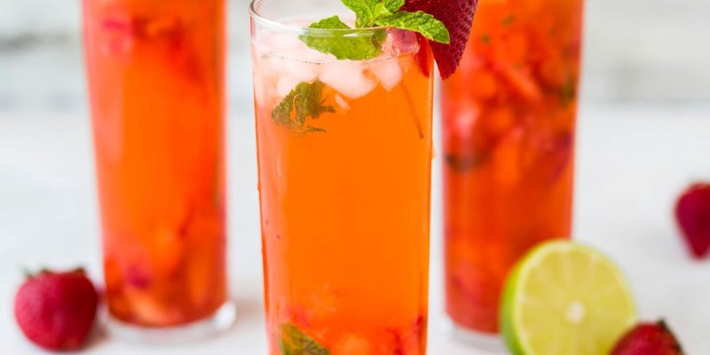 Three cocktails with fruit scattered around them