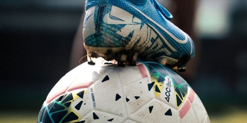 A footballer's boot on top of a football