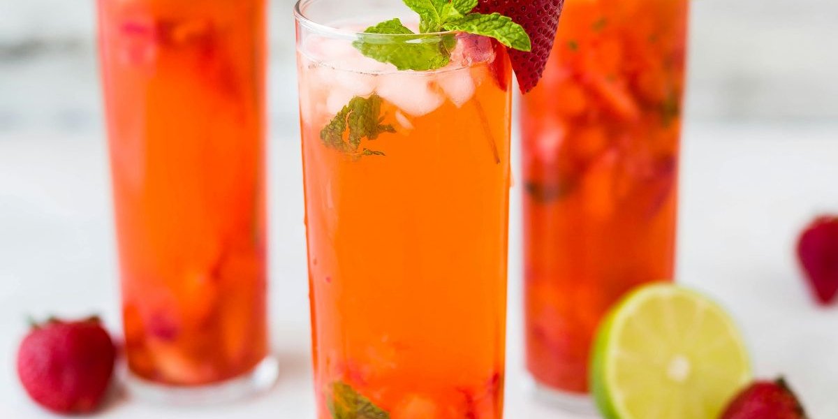 Three cocktails with fruit scattered around them