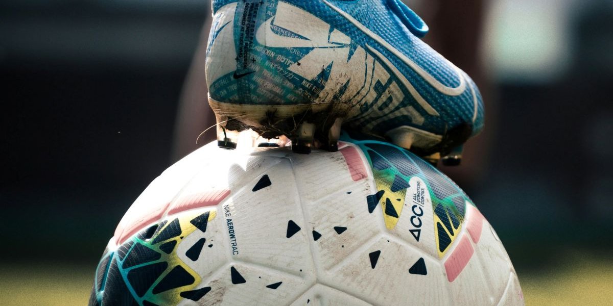 A footballer's boot on top of a football